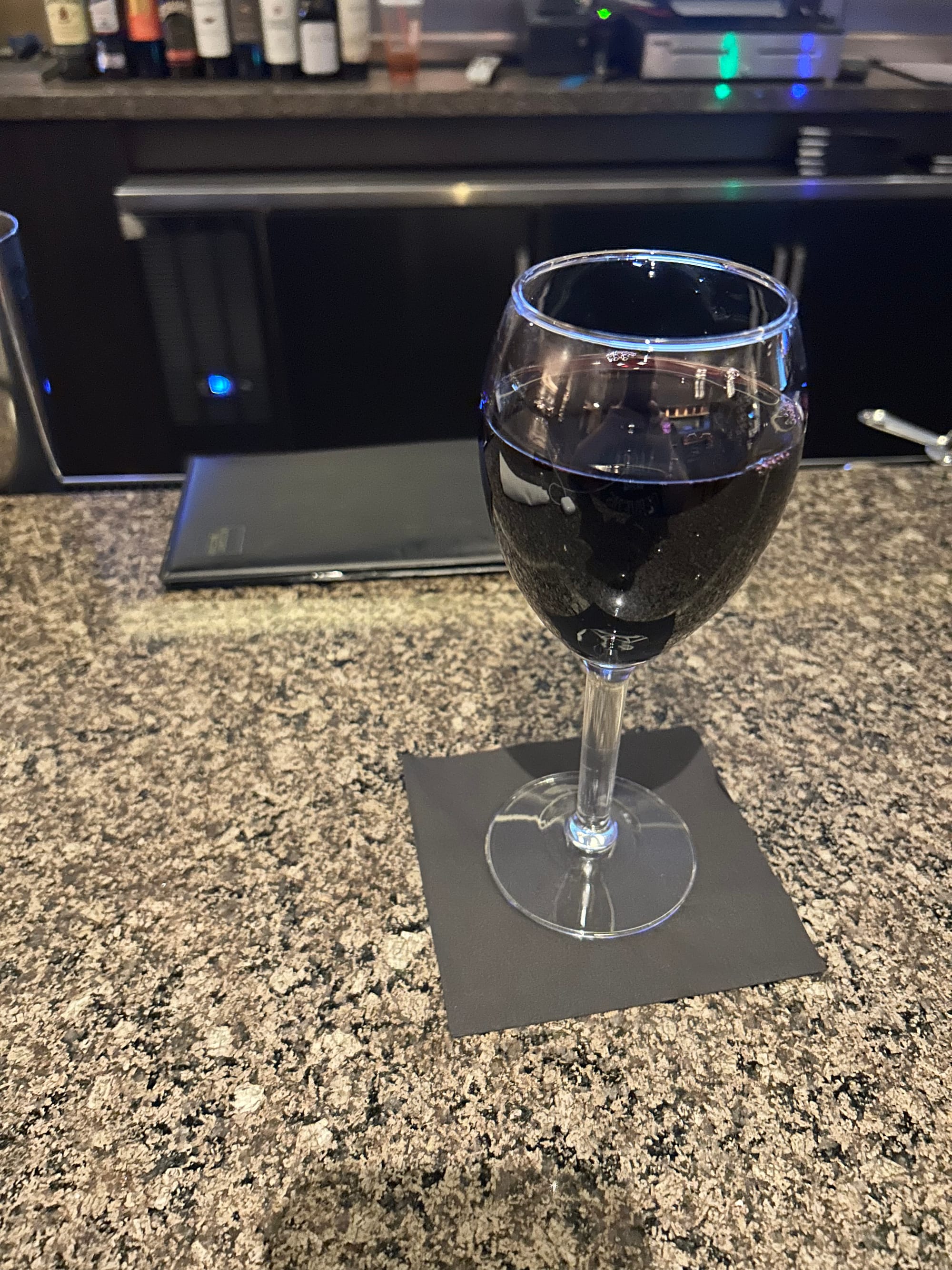 hotel bar, glass of wine, check